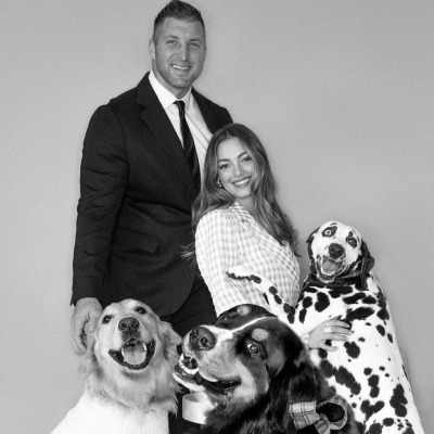 Demi-Leigh Tebow and her husband Tim Tebow posing with their dogs.